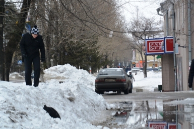 Тротуар полностью залит водой, поэтому прохожие передвигаются по снежным насыпям Баграновская Наталья, ИА EAOmedia