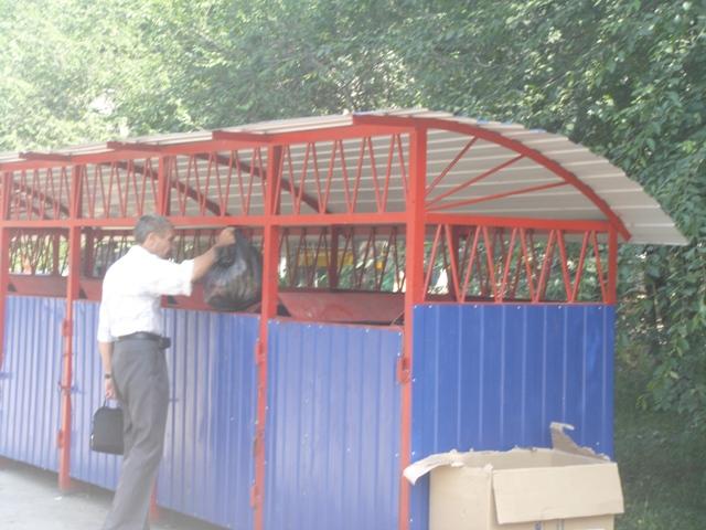 Мужчина выбрасывает мусор в контейнер