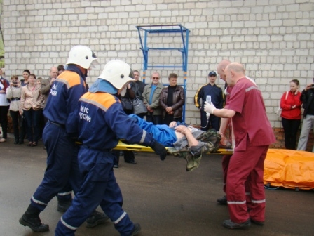 Первого пострадавшего несут в скорую 